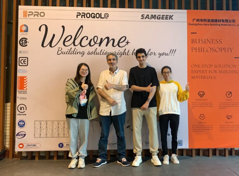 Фотография продавца Progolas & Aprodoor и клиента перед рекламным щитом компании.