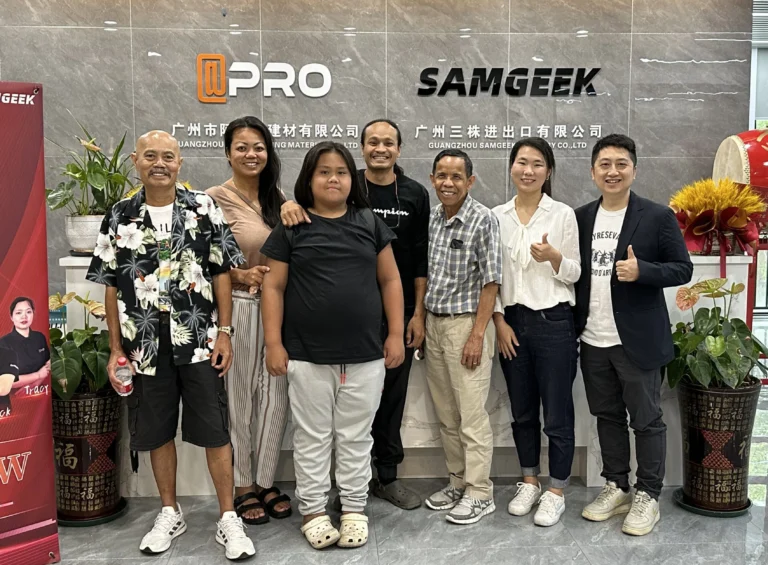 Джейсон, владелец Progolas & Aprodoor, и его клиенты из Южной Азии фотографируются перед дверью компании.