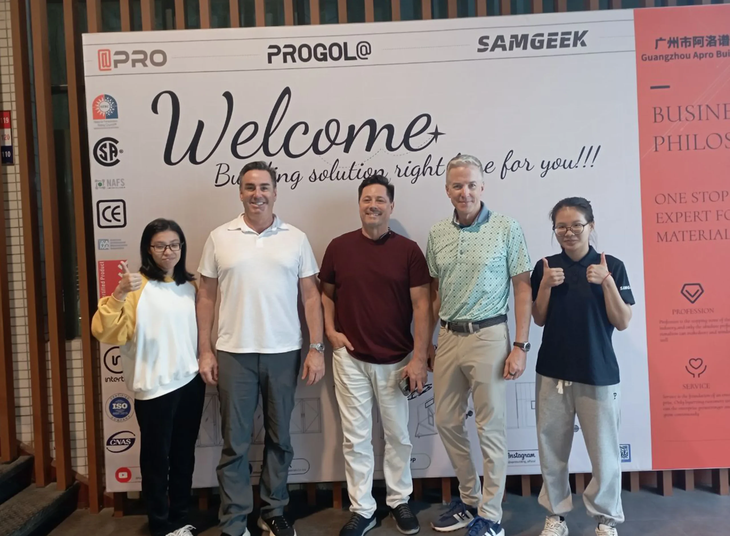 Nancy, a salesperson at Progolas & Aprodoor, took a photo with three foreign clients in front of the company's billboard.