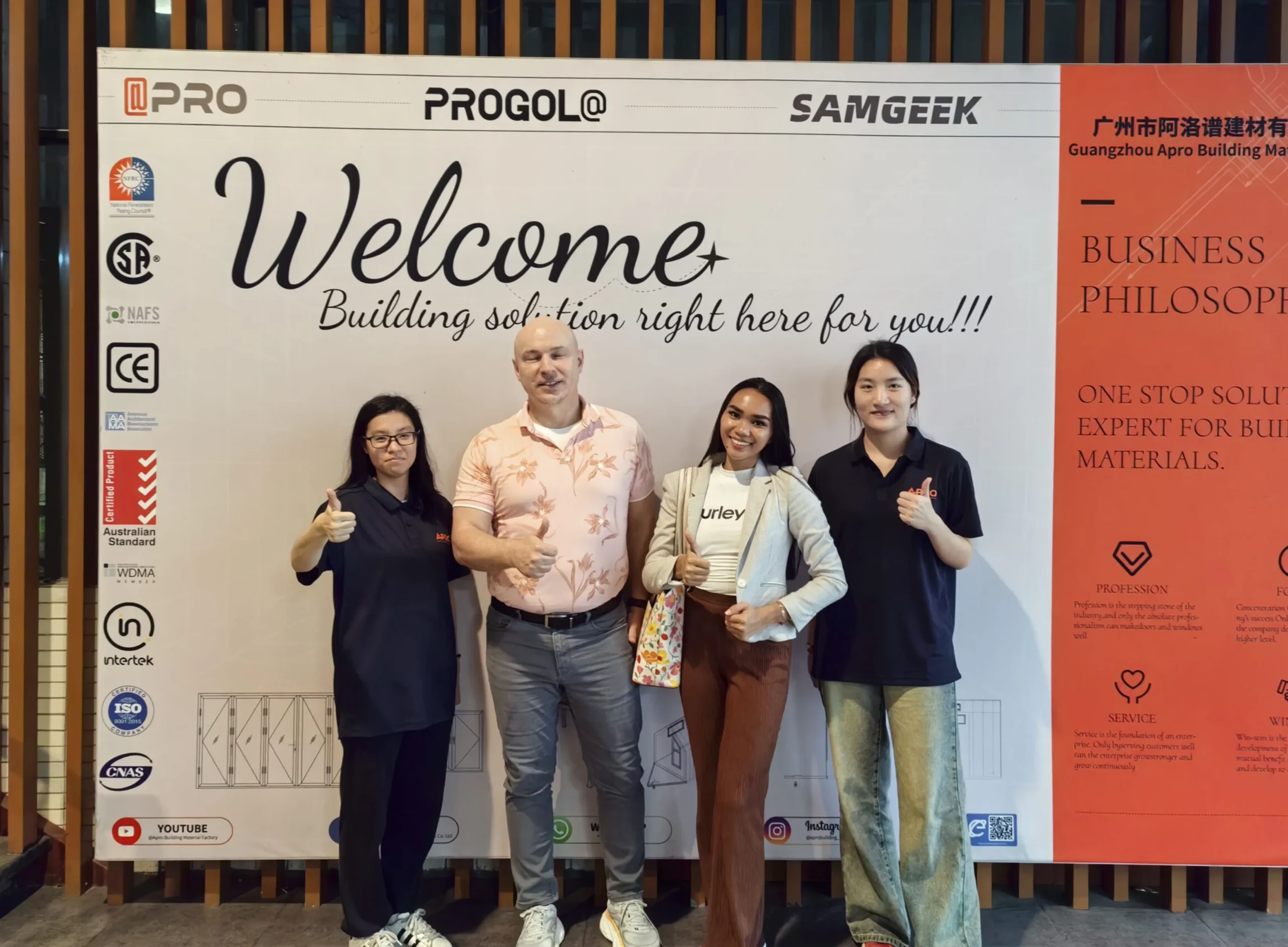 Progolas & Aprodoor salespeople Nancy and Annie took a photo with American clients in front of the company's billboard