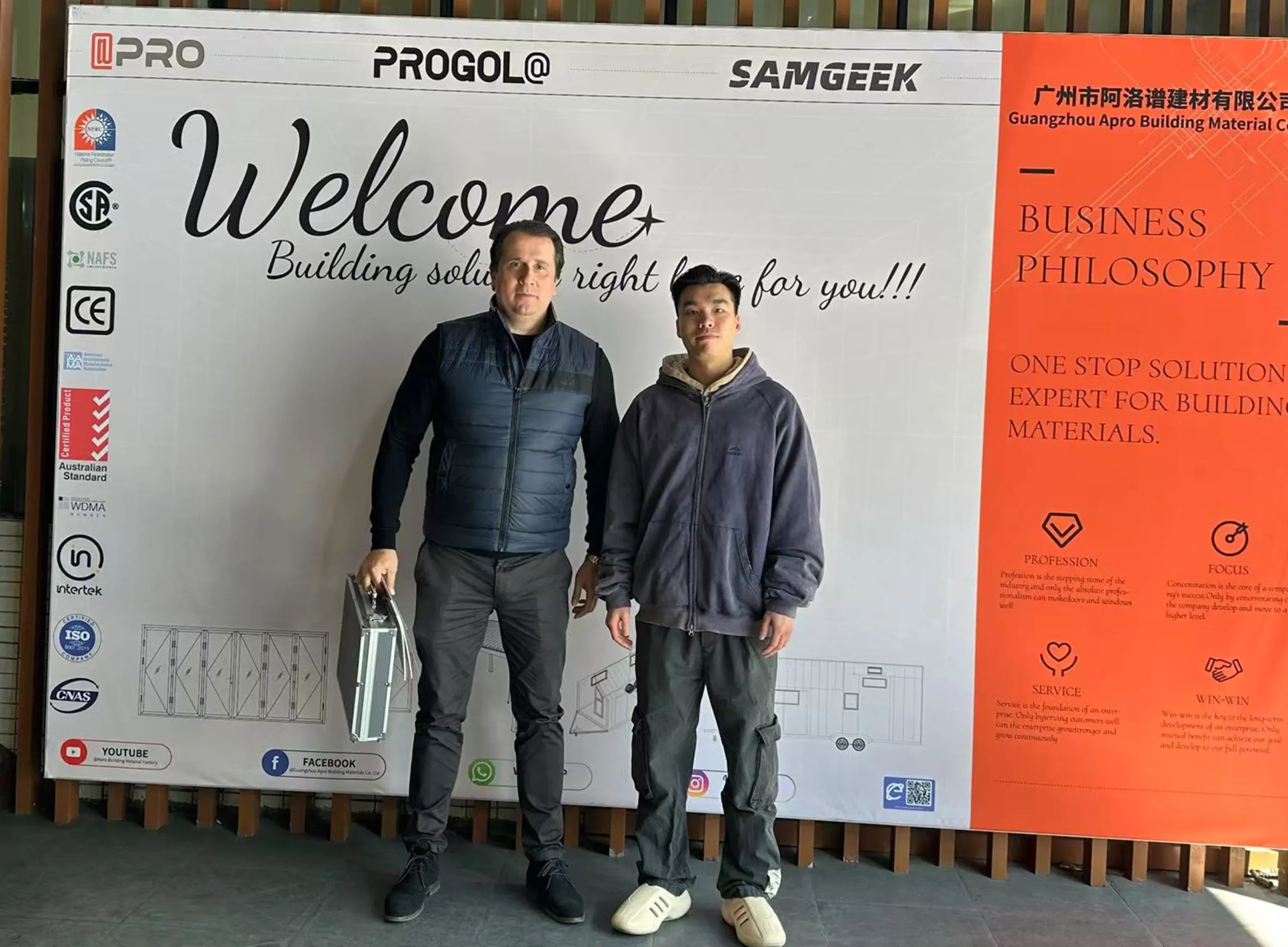 Progolas & Aprodoor salesperson Chirs and American customers took a photo in front of the company's billboard