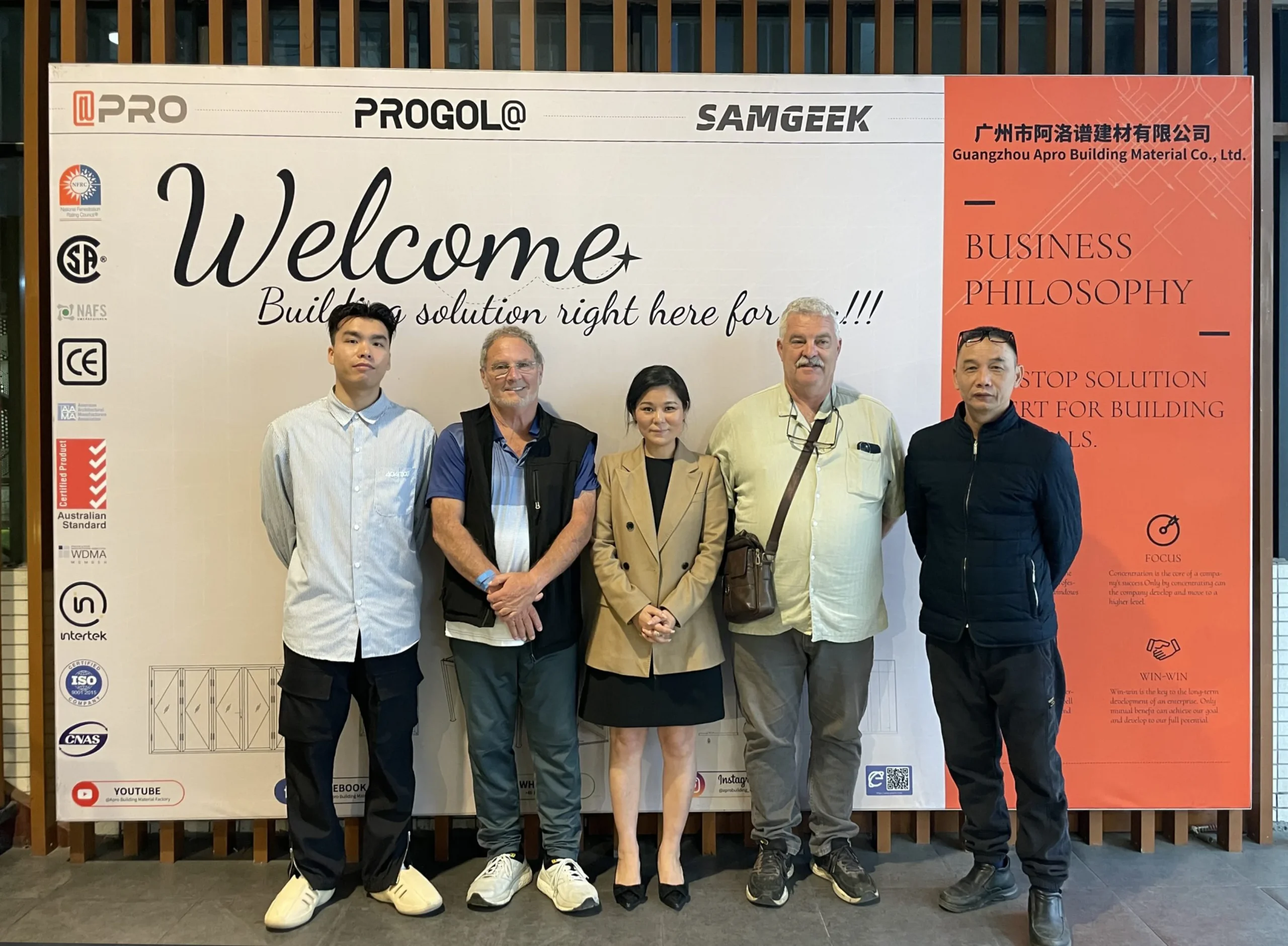 Progolas's deputy general manager and customers pose for a photo in front of the company's billboard