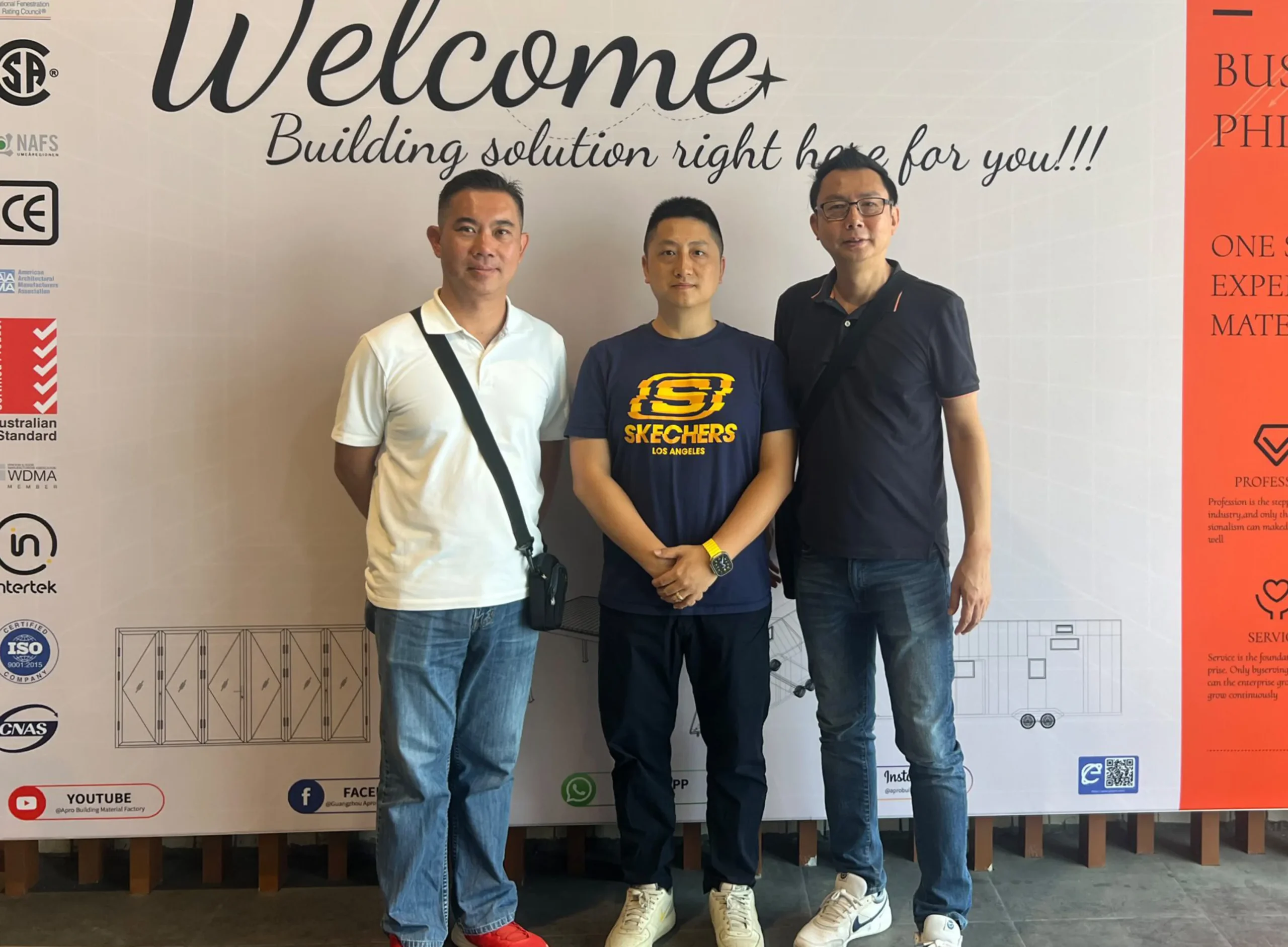 The owner of Progolas & Aprodoor poses with clients in front of the company's billboard